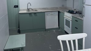 A kitchen with a sink, dishwasher, stove, and refrigerator.