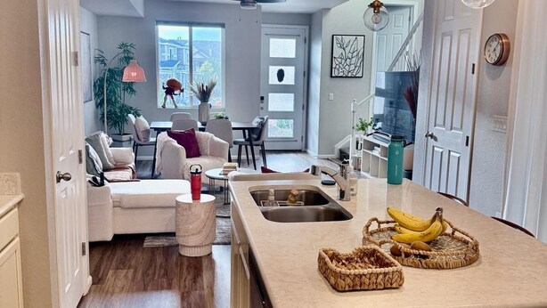 Una cocina moderna con una isla central, una zona de comedor con sofá y vistas al exterior.