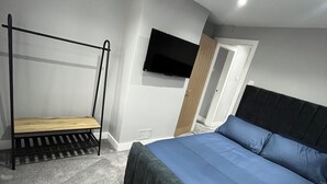 A bedroom with a bunk bed, a TV mounted on the wall, and a door leading to another room. - Fabulous 3-bedroom house in charming Bircotes for your getaway (Bircotes)
