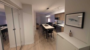Cozinha moderna com área de refeições, micro-ondas e um quadro na parede.