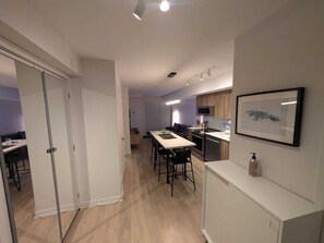 Une cuisine moderne avec un coin repas, un four à micro-ondes et un tableau encadré au mur.