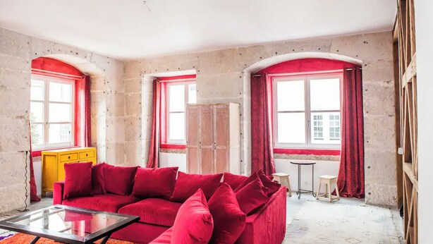 A room with a red sofa, a yellow cabinet, and a glass coffee table. - Grand Historic Alfama Apartment, 4BR, 2WC (Lisboa)