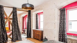 A room with a wooden dresser, a patterned rug, and a hanging light fixture. - Grand Historic Alfama Apartment, 4BR, 2WC (Lisboa)