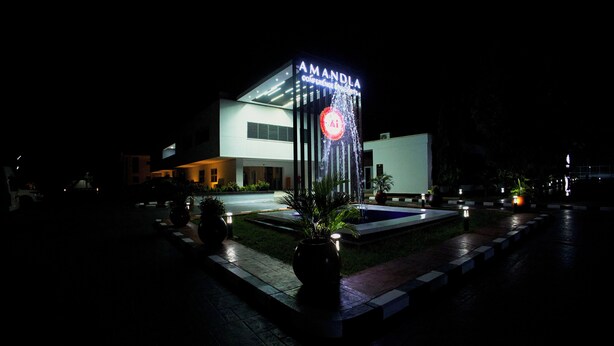 Un edificio moderno con un letrero que dice 'AMANDA' y una fuente en primer plano.