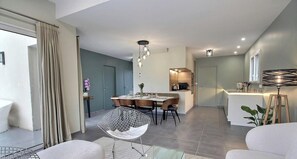 A modern interior with a dining area, kitchen, and living space. - La P'tite Perrosienne (LOUANNEC)