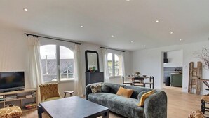 A spacious living room with a sofa, TV, and dining area. - On the quay - TREGUIER (TREGUIER)