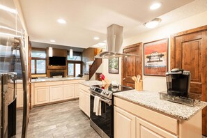 A modern kitchen with granite countertops, stainless steel appliances, and wooden cabinetry. - Park City townhome with 2 bedrooms, den, and 3 baths. (Park City)