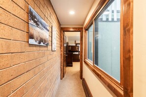 A hallway with brick walls, wooden trim, and a window. - Park City townhome with 2 bedrooms, den, and 3 baths. (Park City)