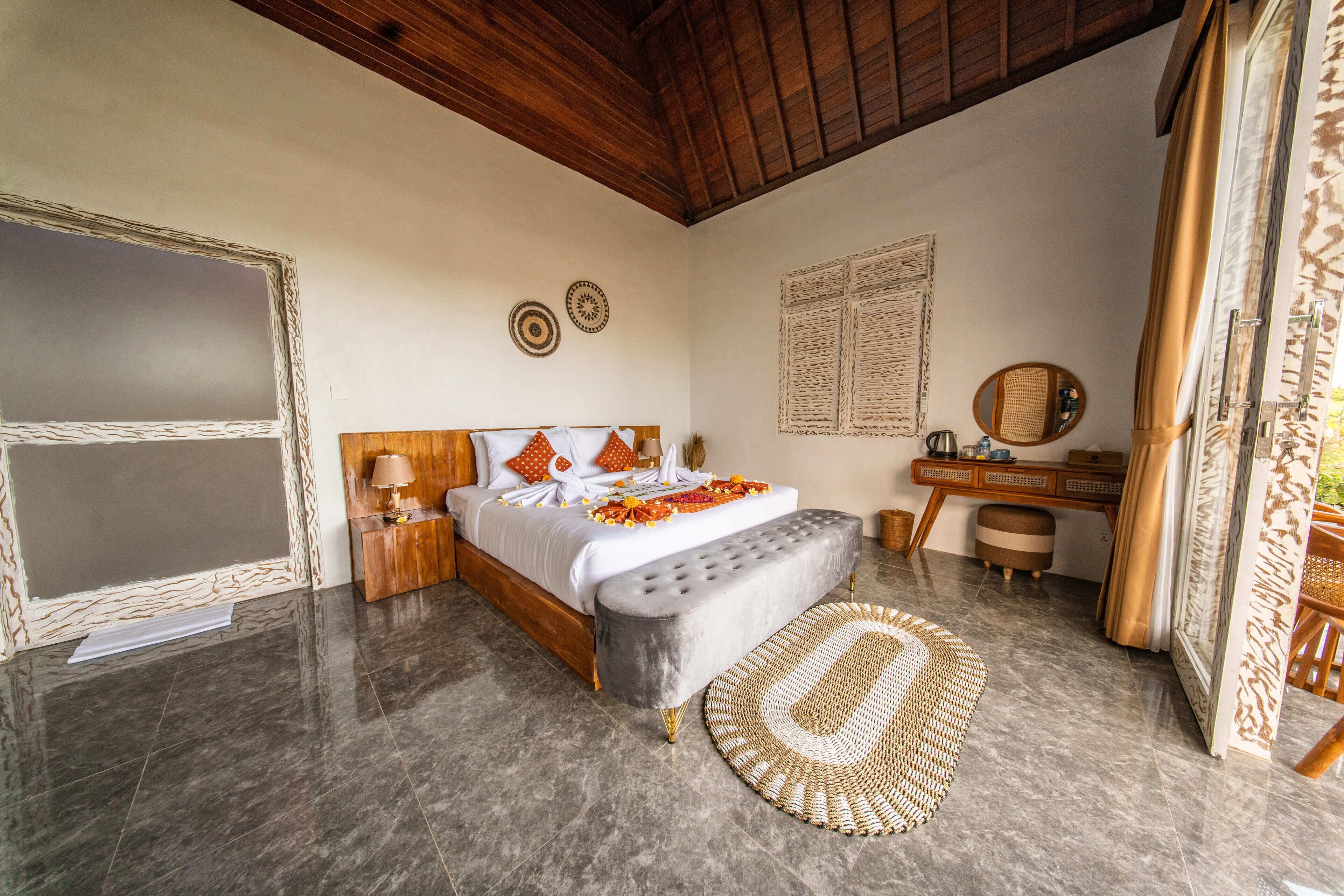 A bedroom with a bed, bedside table, and a desk with a chair.