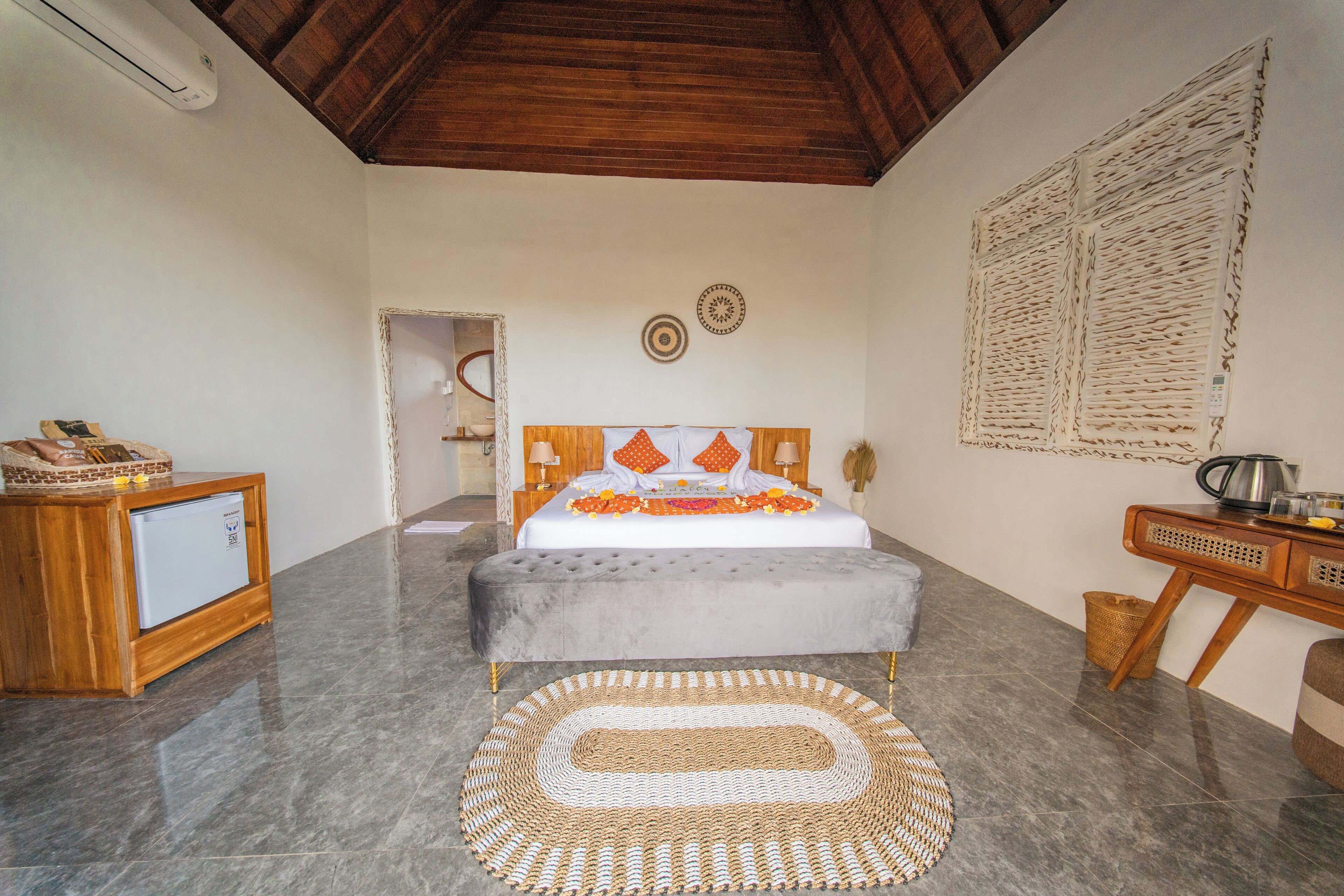 Un dormitorio con cama, mesita de noche y un pequeño armario de madera.