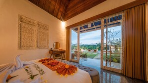 A bedroom with a bed, a desk, a chair, and a view of the outdoors. - Lavanaa Nila-Luxury Resort (Penida Island)