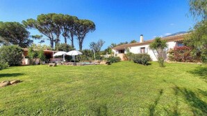 A well-maintained garden with a swimming pool, a patio with umbrellas, and a house with a tiled roof. - Villa I Pini - PORTO VECCHIO (PORTO VECCHIO)