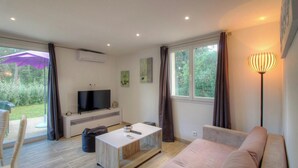 A modern living room with a flat-screen TV, a sofa, a coffee table, and a floor lamp. - Villa I Pini - PORTO VECCHIO (PORTO VECCHIO)