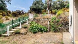 A staircase leading up to a stone wall with a wooden fence, surrounded by greenery and trees. - Campo Sotano - VENACO (VENACO)