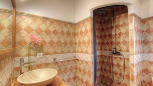 Un baño con ducha, lavamanos y espejo.
