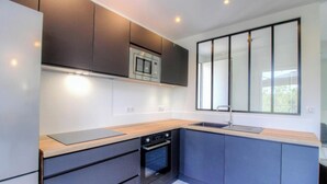 Una cucina moderna con elettrodomestici integrati, un'ampia finestra e un design minimalista.