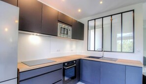A modern kitchen with built-in appliances, a large window, and a minimalist design. - A casa Tomi - SERRA DI FERRO (SERRA DI FERRO)