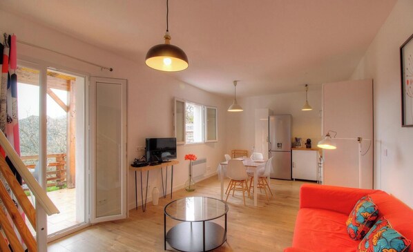 Un espacio habitable moderno con comedor, cocina y un amplio ventanal.
