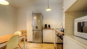 Cocina compacta con refrigerador, microondas y cafetera.