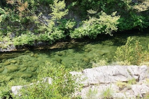 A clear river with rocky banks and dense greenery. - Travu Valley 2 (VENTISERI)