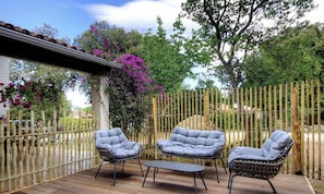 A wooden deck with two cushioned chairs and a small table. - Travu Valley 2 (VENTISERI)