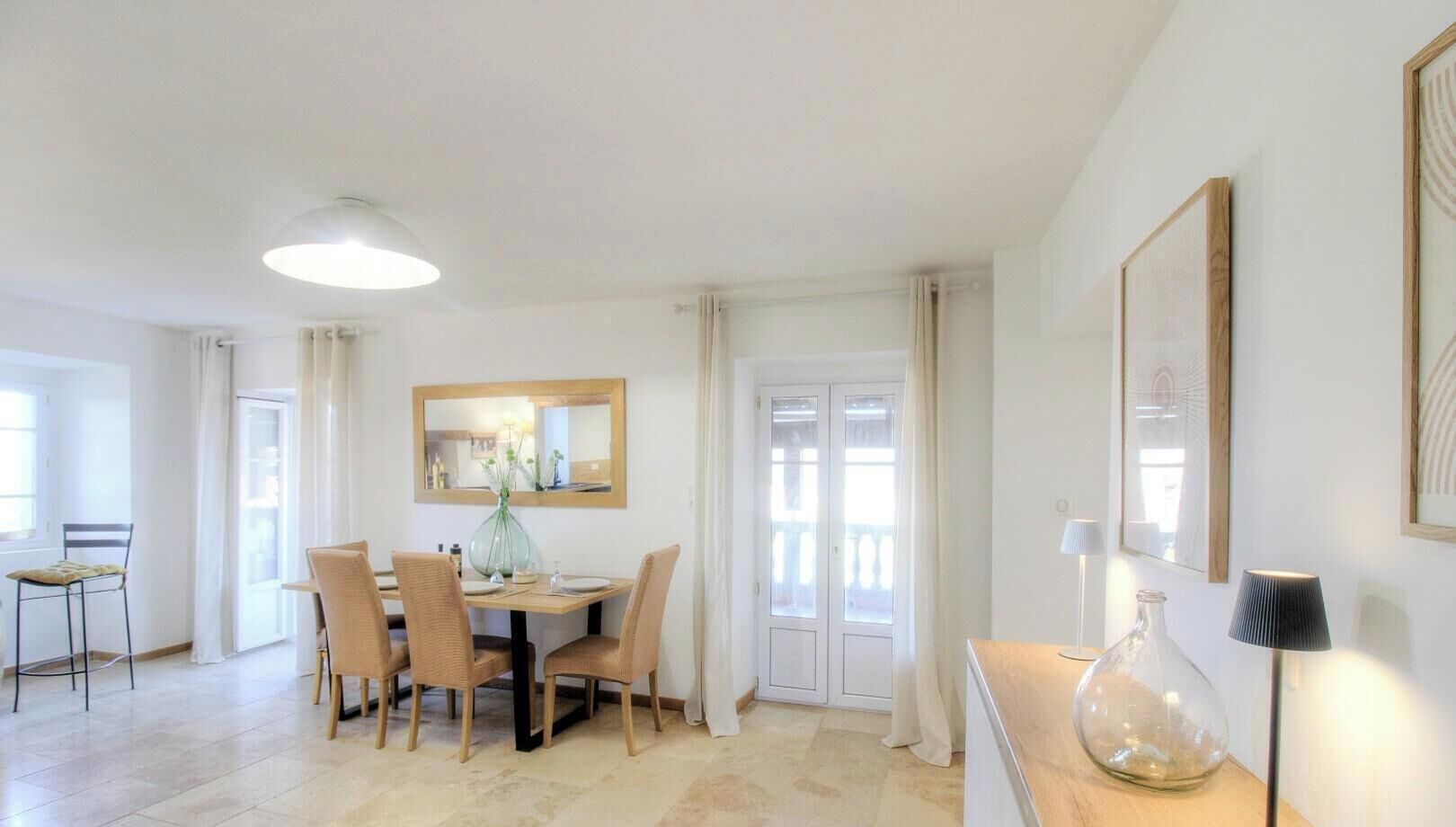A dining area with a table, chairs, a vase, and a lamp.