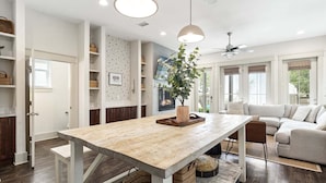 A modern kitchen with a wooden table, built-in shelves, and a ceiling fan. - New Apres Beach, Sleeps 14, Private Pool, 3 Min walk to the beach, Main House + Carriage (Inlet Beach)