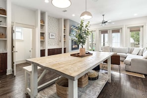 Eine moderne Küche mit Holztisch, Einbauschränken und Deckenventilator.