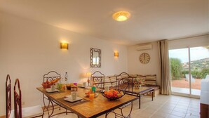 A dining area with a table set for breakfast, chairs, a clock, and a view of the outdoors. - Tivella House - TIZZANO (TIZZANO)