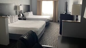 A hotel room with two beds, a desk, a chair, a TV, and a window with curtains. - One Unit w/ Two Queen Beds | Breakfast Included | Direct Pool & Jacuzzi Access (Houghton Lake)
