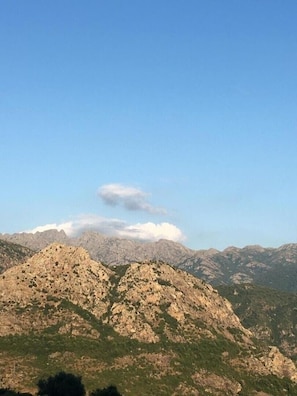 Paisaje montañoso con terreno rocoso y vegetación escasa.
