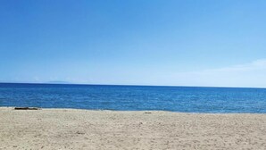 Ein Strand mit blauem Himmel und ruhiger See.