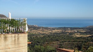 A coastal view with a building featuring a balcony with plants and a white object on it. - Le 51364 - AREGNO - Gîte (AREGNO)