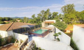 Ein Wohnhaus mit Schwimmbad, Steinmauern und Blick auf die umliegende Landschaft.