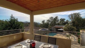 A balcony with a table set for dining, overlooking a swimming pool and a mountainous landscape. - Du soleil - PORTO VECCHIO (PORTO VECCHIO)