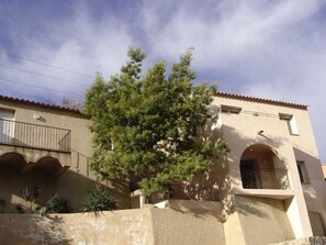 A building with a balcony, arched windows, and a tree in front. - Malaga - OCCHIATANA - Bed and Breakfast (OCCHIATANA)