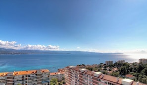Eine Küstenstadt mit Gebäuden, einem klaren Himmel und Blick auf das Meer.