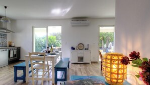 A modern kitchen with a dining area, large windows, and a decorative lantern. - Villa E Lecce - SANTA LUCIA DI MORIANI (SANTA LUCIA DI MORIANI)