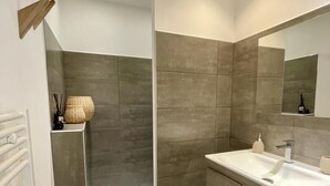 Un bagno moderno con vasca, mobile lavabo con specchio e cabina doccia.