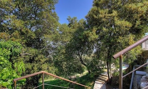 Eine Treppe führt zu einem von Bäumen umgebenen Gebäude.