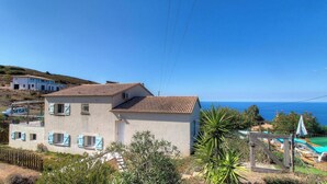 A two-story building with a tiled roof, a balcony, and a view of the sea. - Domaine des yuccas - CALCATOGGIO (CALCATOGGIO)