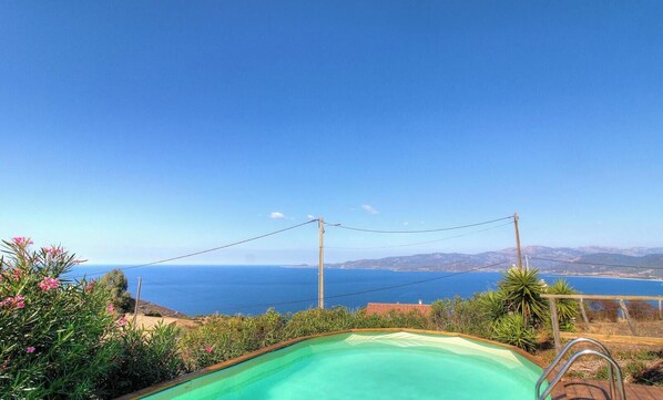 Ein Schwimmbecken mit Blick auf das Meer und die Berge.