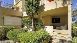 A residential building with a covered outdoor seating area, a garage, and a well-maintained garden. - Résidence U Quarciu - GHISONACCIA (GHISONACCIA)