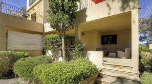 Ein Wohnhaus mit überdachter Terrasse, Garage und gepflegtem Garten.