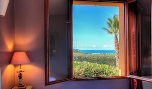 A room with a window overlooking a landscape with a palm tree and a view of the ocean. - Le 693 - PROPRIANO - Gîte (PROPRIANO)