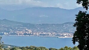 A coastal cityscape with a view of the sea and distant mountains. - Villa des oliviers - OLMETO (OLMETO)