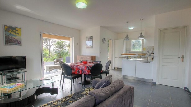 A modern living room with a TV, dining area, and kitchen. - Villa des oliviers - OLMETO (OLMETO)