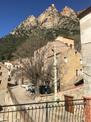 A mountainous village with stone buildings, a paved street, and parked cars. - I Monti Signori - OTA (OTA)