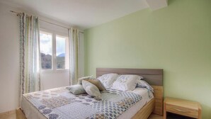 Una camera da letto con un letto, tende, un comodino e una finestra.