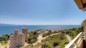 Un paysage urbain côtier avec des bâtiments, une route et une vue sur la mer.